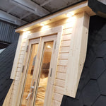 Close-up of entrance doors on The Hearthwood Pod luxury 2 person glamping pod with timber cladding and exterior lighting