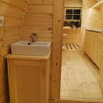 Interior bathroom sink area inside The Hearthwood Pod luxury 2 person glamping pod with timber cabinetry and modern basin