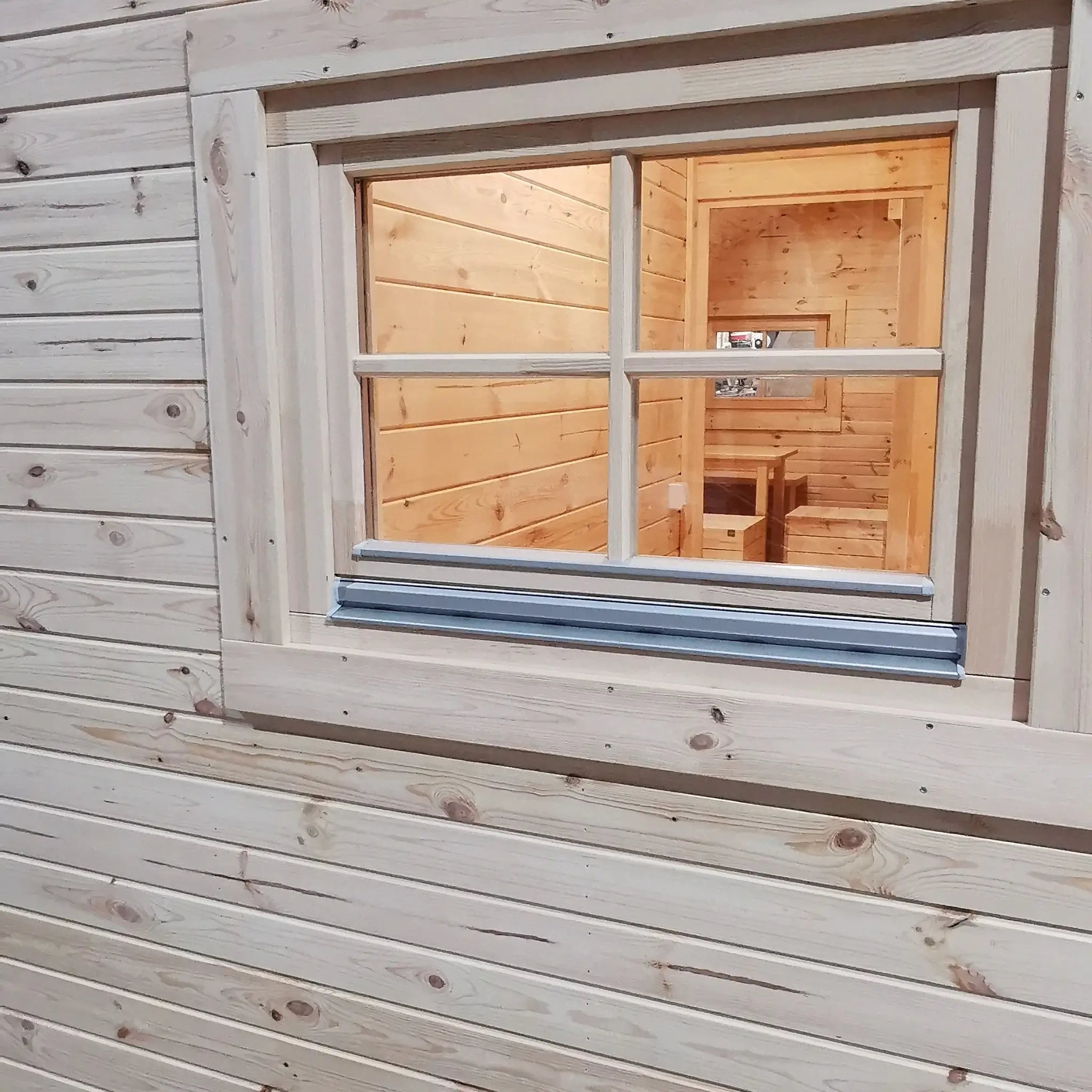 Exterior rear window view of the Hearthwood luxury 6 person glamping pod with natural wood finish