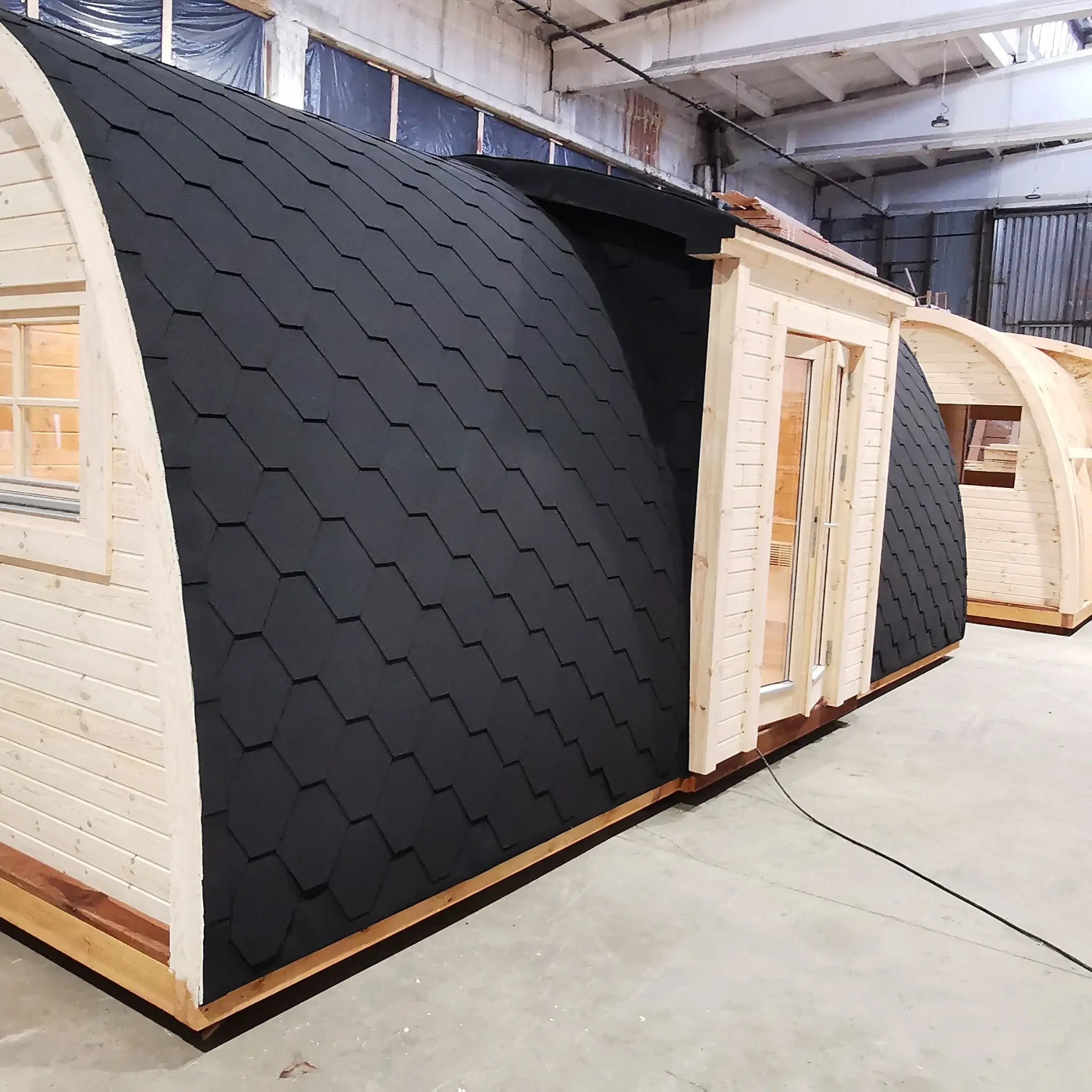 Angled side exterior view of the Hearthwood luxury 6 person glamping pod highlighting curved structure