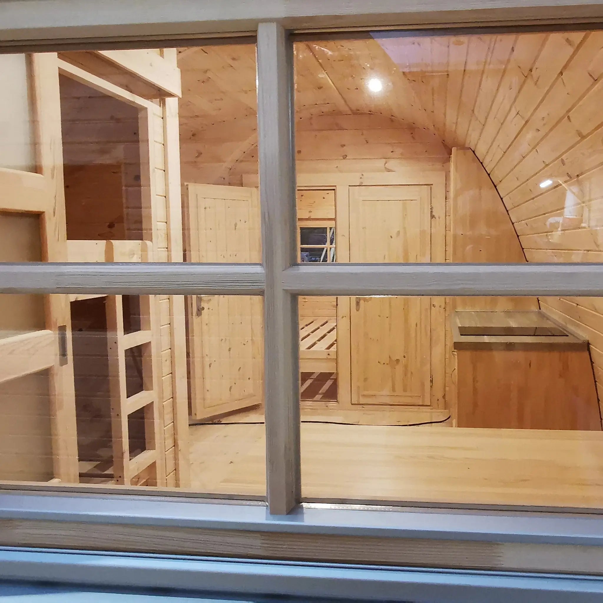 View inside the Hearthwood luxury 6 person glamping pod through the rear window showing interior layout