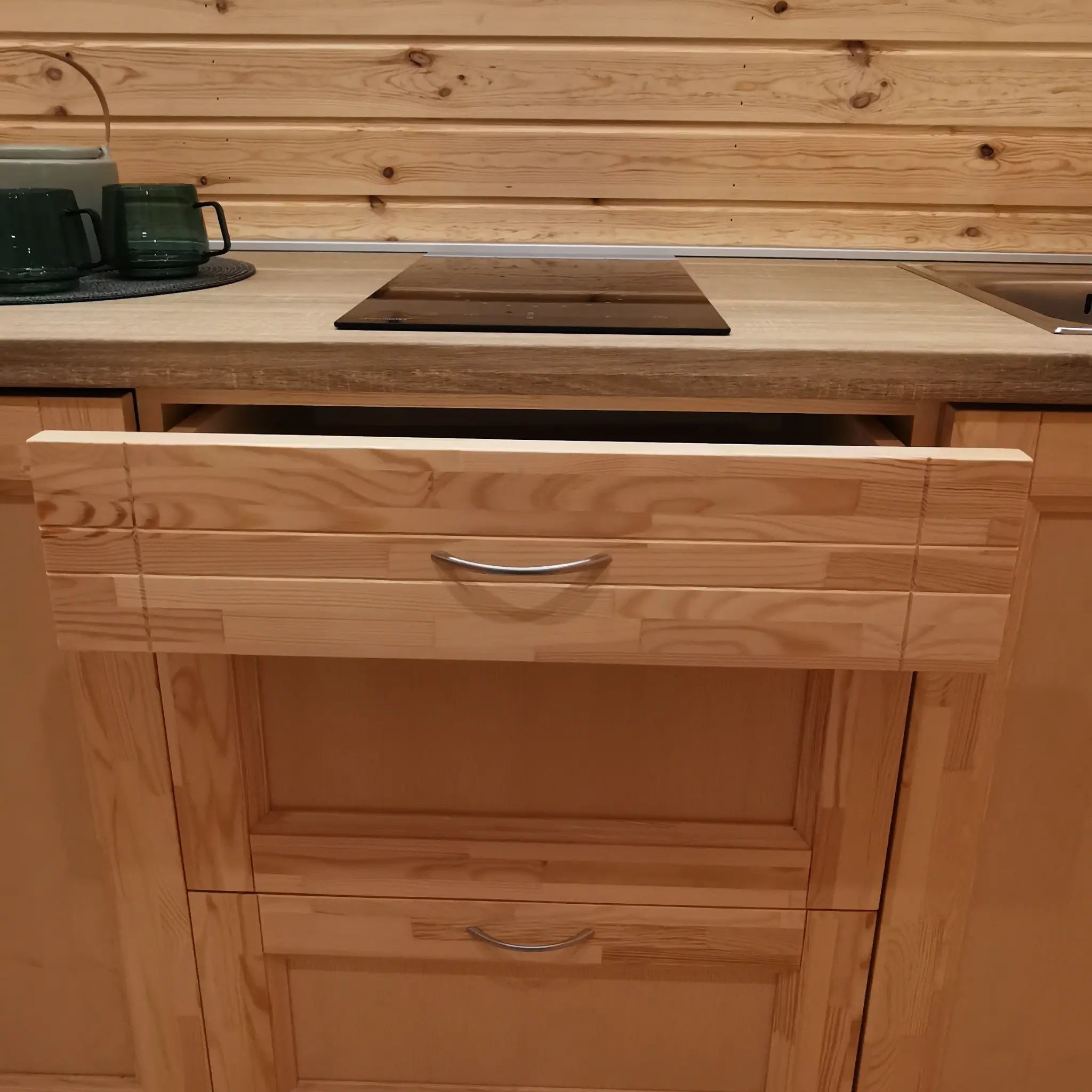 Compact kitchen with electric hob and open drawer inside The Hearthwood Pod