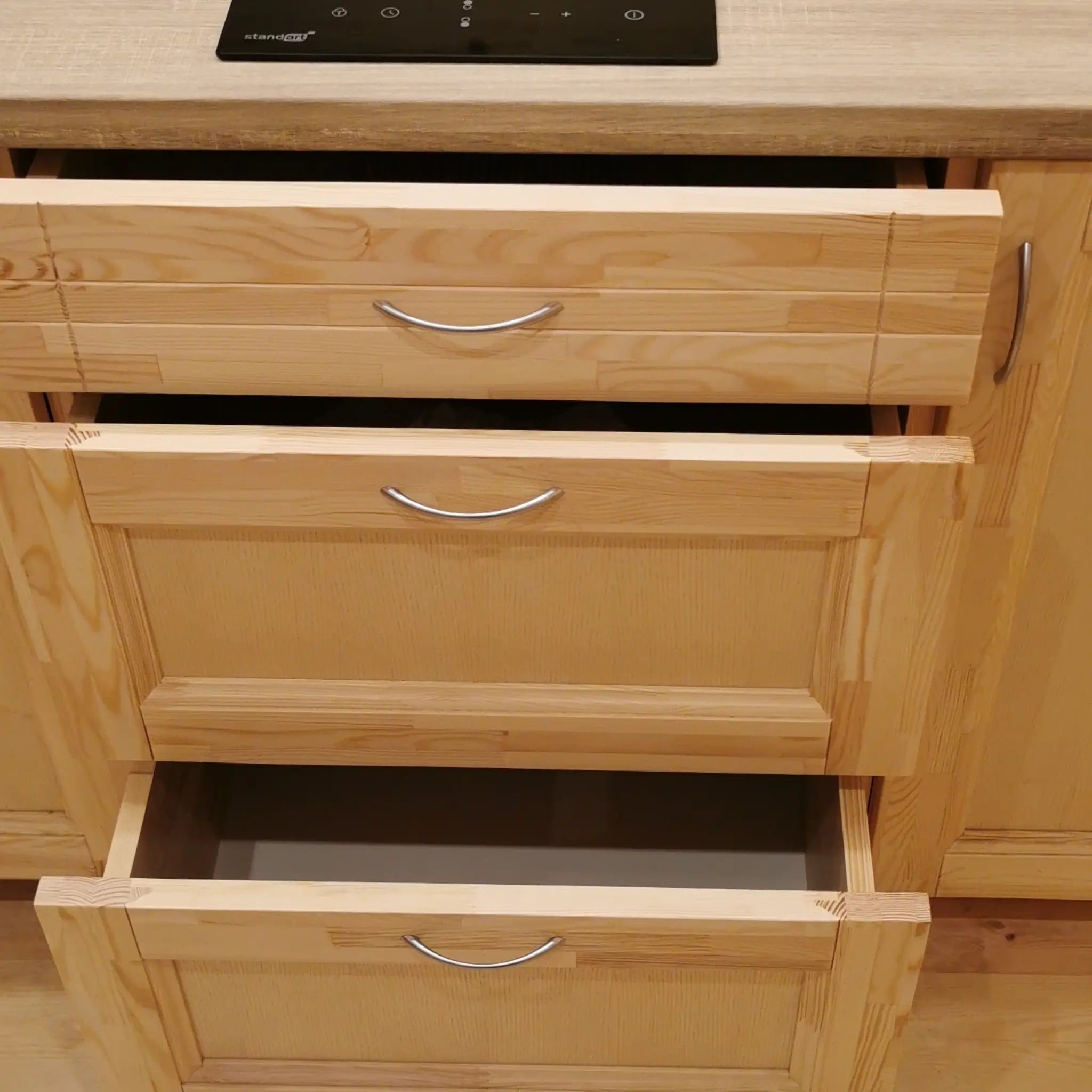 Solid wood kitchen drawers inside luxury glamping pod, showcasing handcrafted storage and natural timber detailing