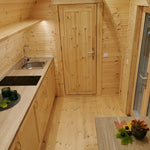 Interior view showing kitchen and bathroom entrance inside The Hearthwood Pod