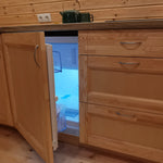 Compact integrated fridge inside luxury glamping pod kitchen, ideal for short-stay accommodation