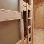 Close-up of wooden bunk bed with sliding door and integrated ladder inside the Hearthwood Pod luxury 6 person glamping accommodation