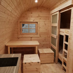 Open-plan interior with dining area, kitchenette, and bunk beds in The Hearthwood Pod luxury glamping pod
