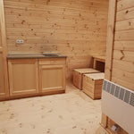 Spacious dining nook with wooden table and bench seating inside the Hearthwood luxury 6 person glamping pod