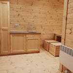 Curved timber interior featuring kitchenette, dining area, and compact radiator in the Hearthwood 6 berth glamping pod