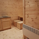 Spacious dining nook with wooden table and bench seating inside the Hearthwood luxury 6 person glamping pod