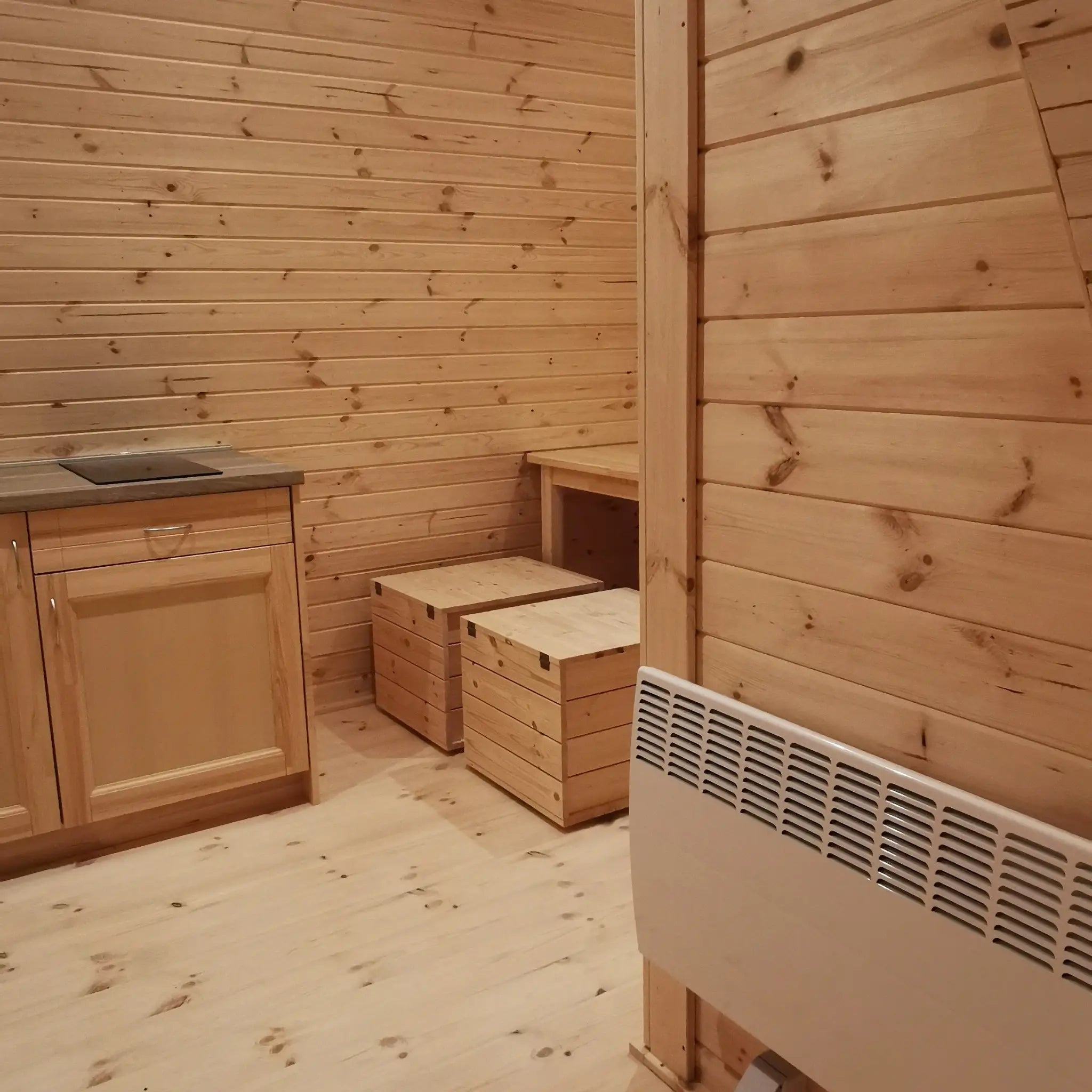 Spacious dining nook with wooden table and bench seating inside the Hearthwood luxury 6 person glamping pod