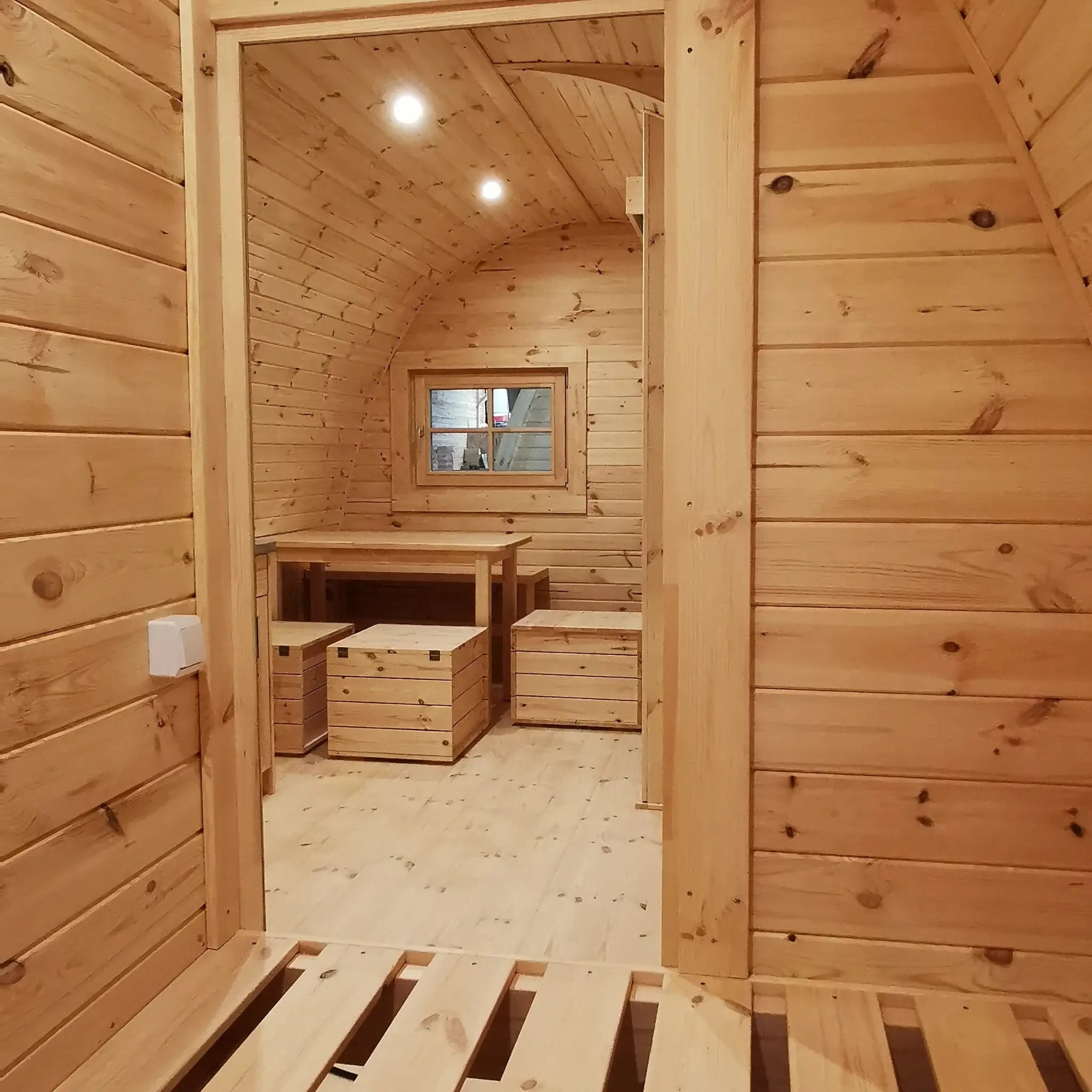 Interior perspective from double bed towards dining and living area in the Hearthwood Pod luxury glamping pod