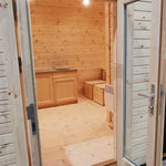 Entrance view into the Hearthwood Pod showing open-plan dining area and timber interior finish