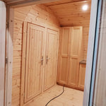 Wide interior view from entrance door highlighting dining space and layout of the Hearthwood Pod 6 person glamping pod