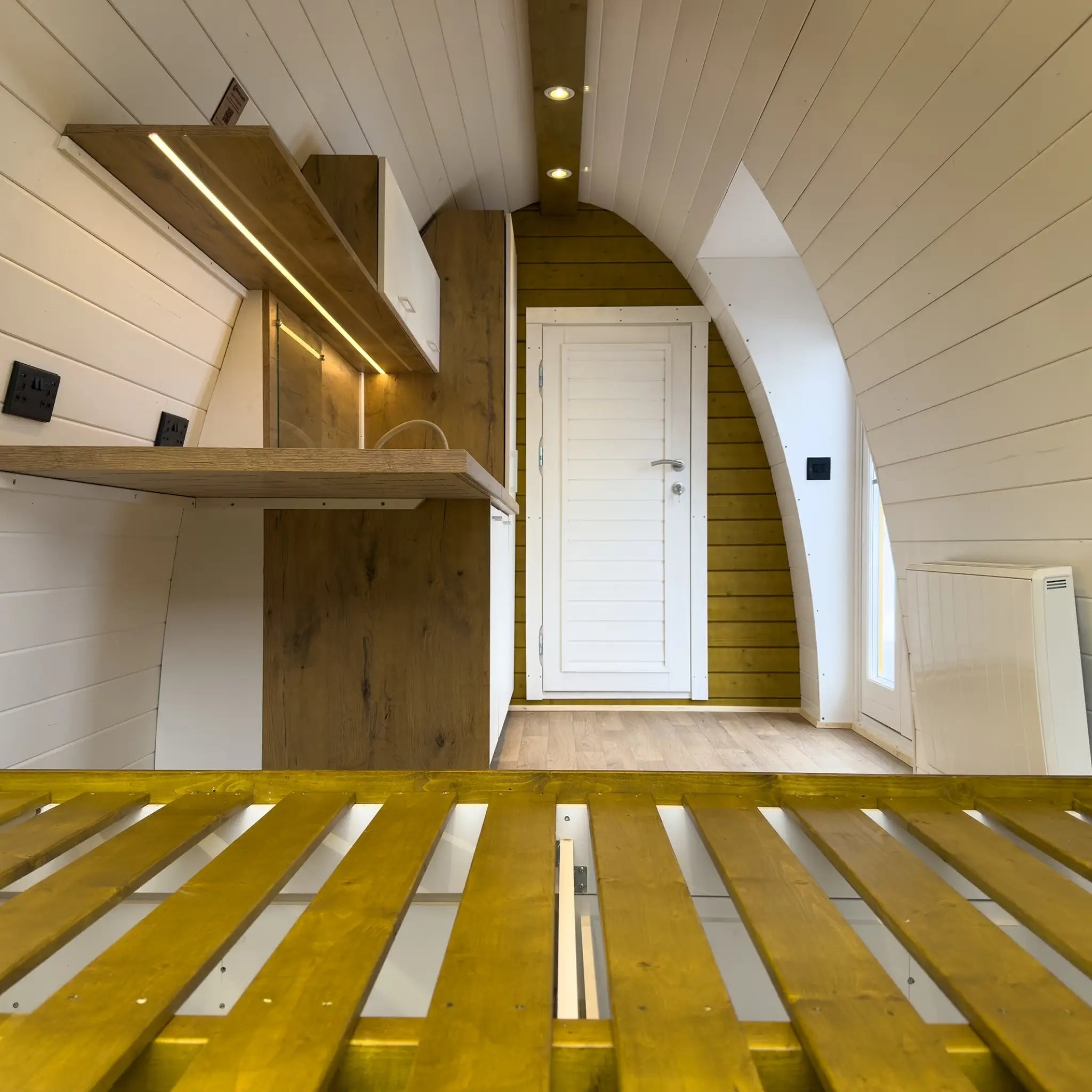 Interior View from Bed Toward Kitchen and Entrance in Hobbit Pod