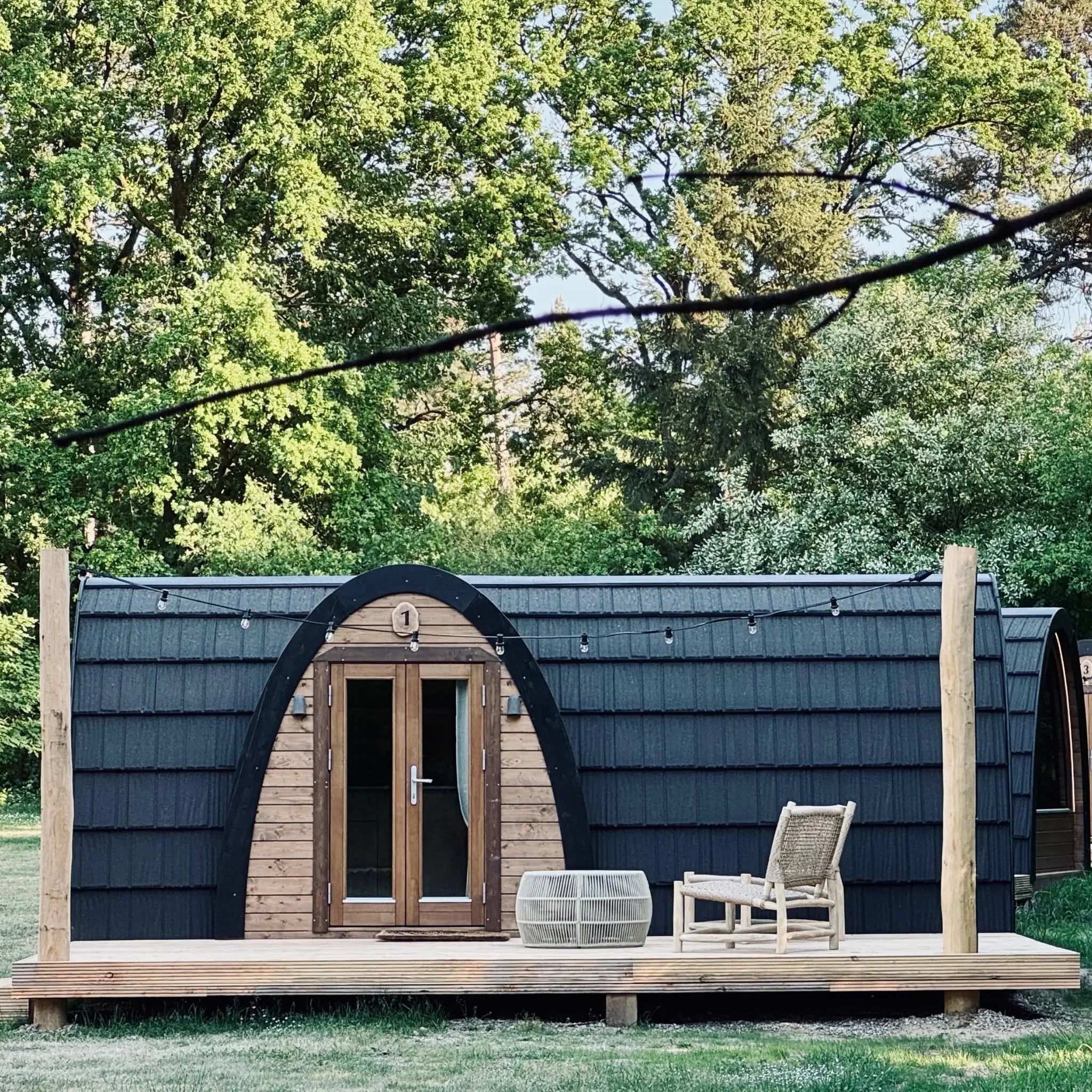 Front close-up of The Hobbit Pod luxury glamping pod with timber entrance and outdoor decking