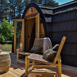 Angled exterior view of The Hobbit Pod luxury glamping pod with timber decking and entrance doors