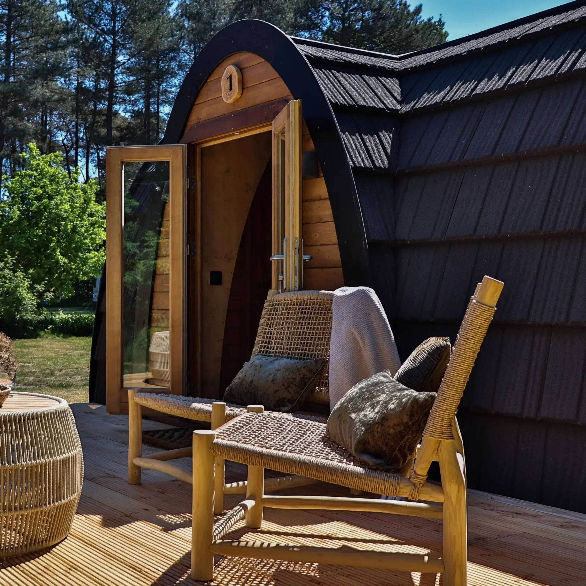 Angled exterior view of The Hobbit Pod luxury glamping pod with timber decking and entrance doors