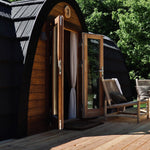 Side view of The Hobbit Pod luxury glamping pod with open entrance and outdoor seating