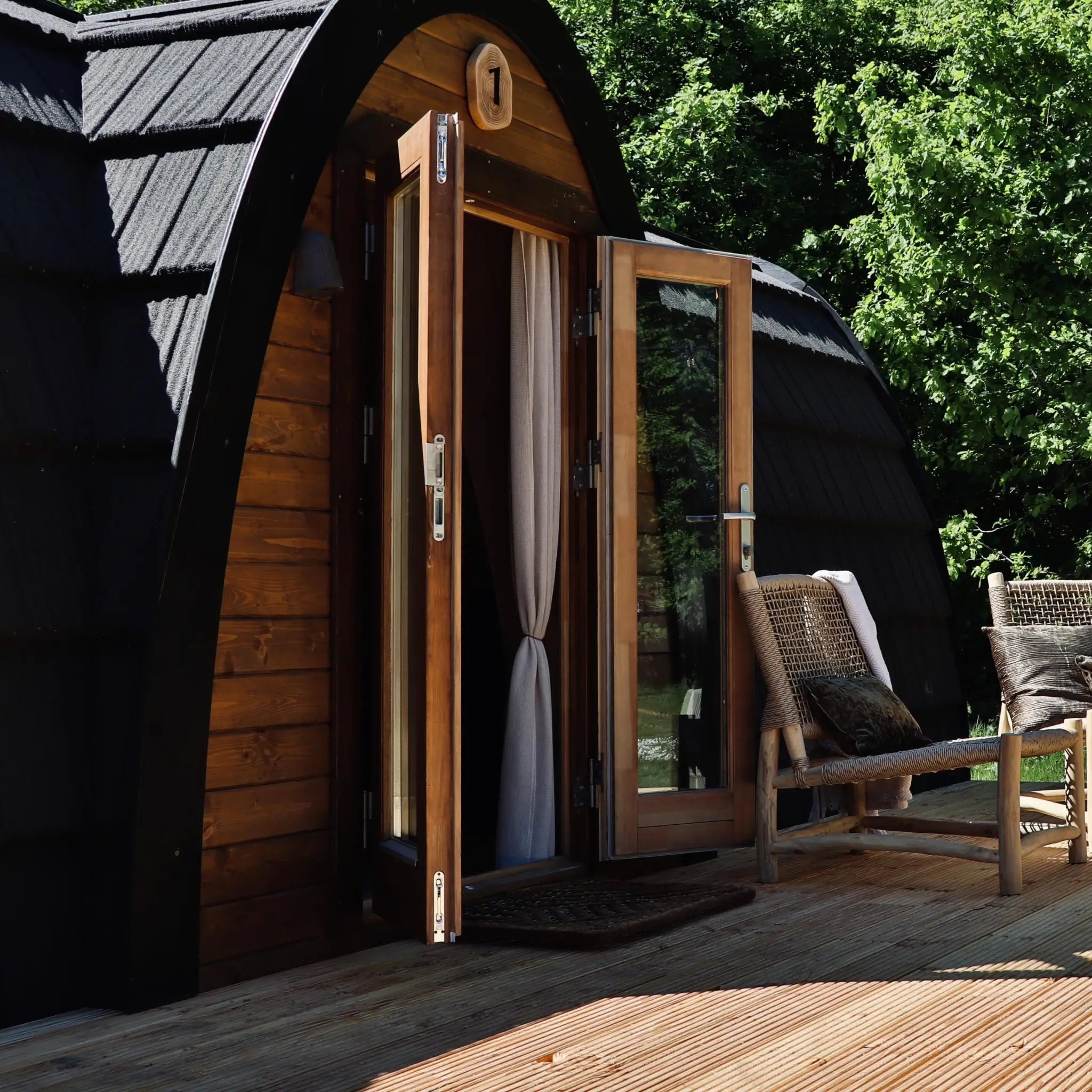 Side view of The Hobbit Pod luxury glamping pod with open entrance and outdoor seating