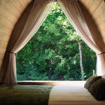 Double bed beside the panoramic picture window inside The Hobbit Pod luxury glamping pod