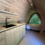 Open-plan interior with kitchenette and sleeping area inside The Hobbit Pod luxury glamping pod