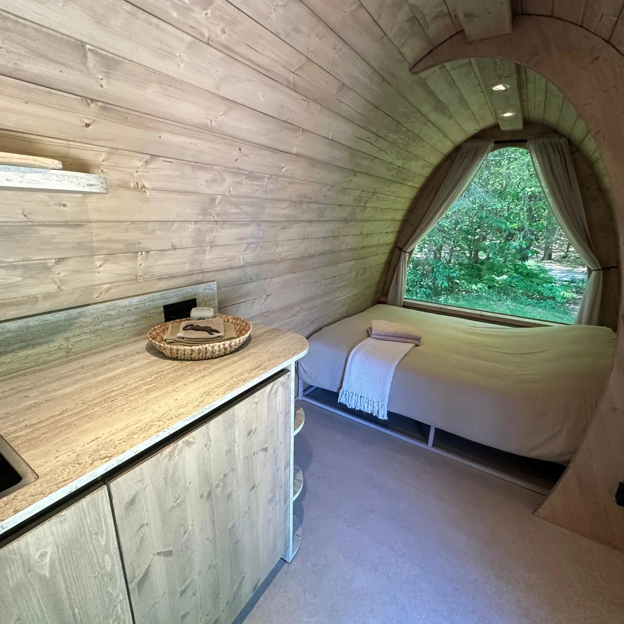 Luxury sleeping area with panoramic woodland views inside The Hobbit Pod glamping pod