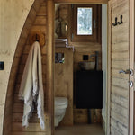 Compact ensuite bathroom with toilet and stone basin inside The Hobbit Pod luxury glamping pod