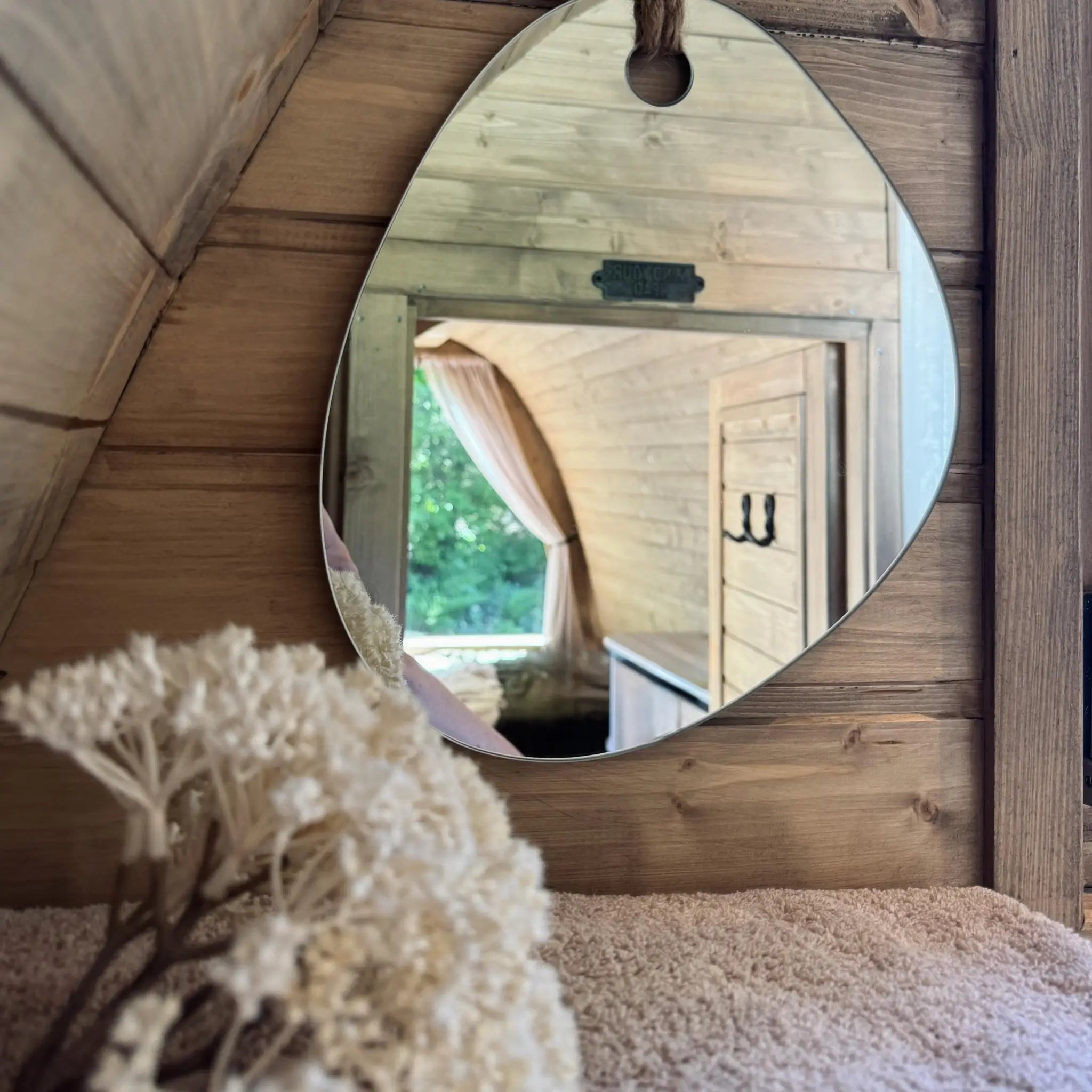 Decorative mirror and natural timber interior inside The Hobbit Pod luxury glamping pod