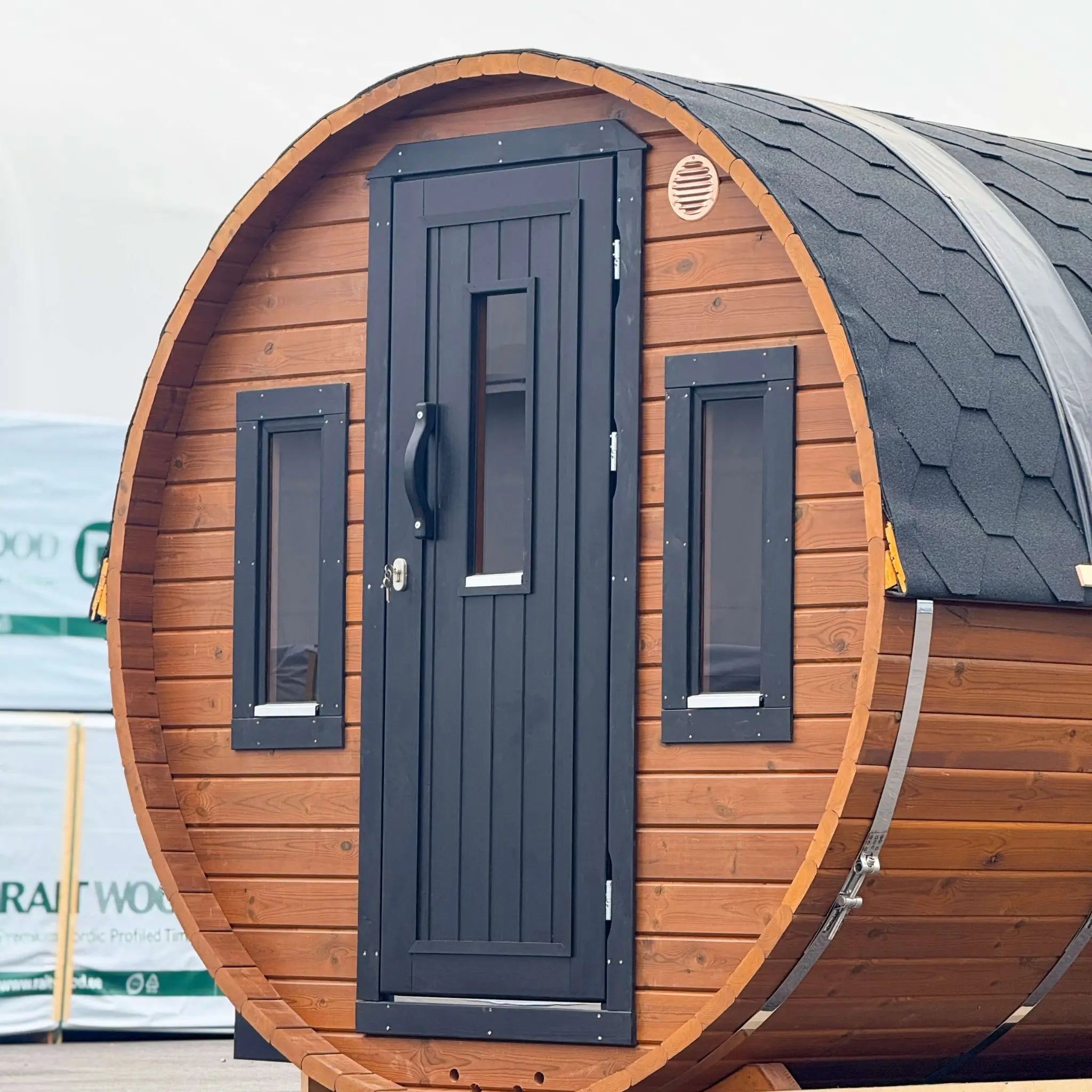 Front perspective of the Infinity Glass luxury 8 person barrel sauna