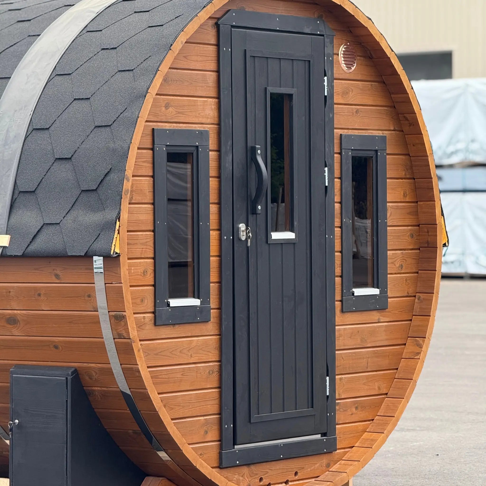 Front view of the Infinity Glass luxury 8 person barrel sauna with changing room