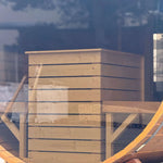 View through the panoramic rear glass wall showing the sauna heater safety guard