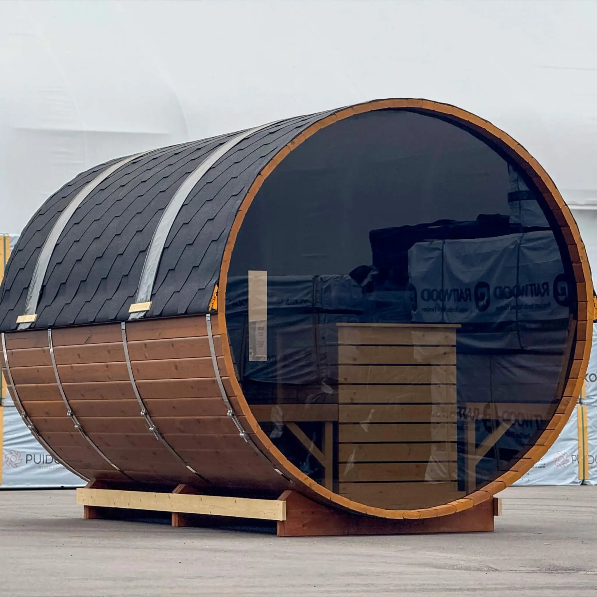 Angled rear view of the Infinity Glass barrel sauna with full panoramic glass wall