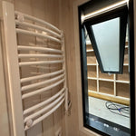 The Large GlampTainer container-style glamping unit – sleek white towel dryer mounted beside tall opened bathroom window