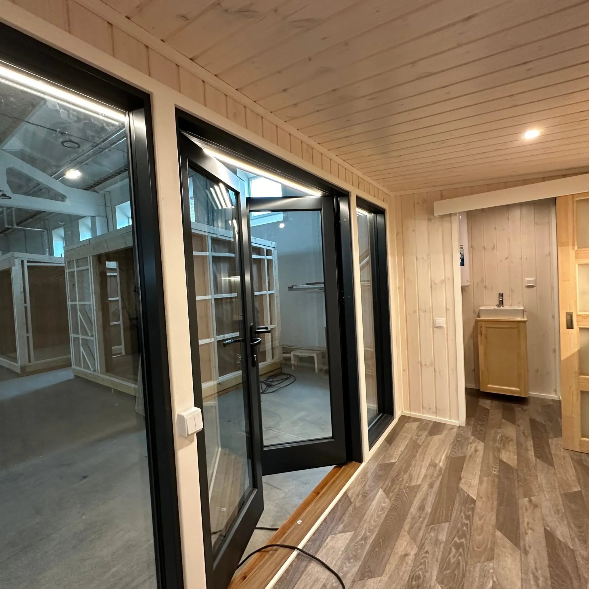 The Large GlampTainer container-style glamping unit – view through interior showing bathroom area and full-glass double front doors