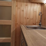 The Medium GlampTainer container-style glamping structure – modern stainless steel sink with curved tap set against vertical timber cladding