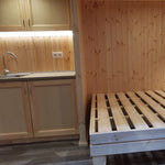 The Medium GlampTainer container-style glamping structure – space-saving layout with kitchenette beside built-in wooden bed frame