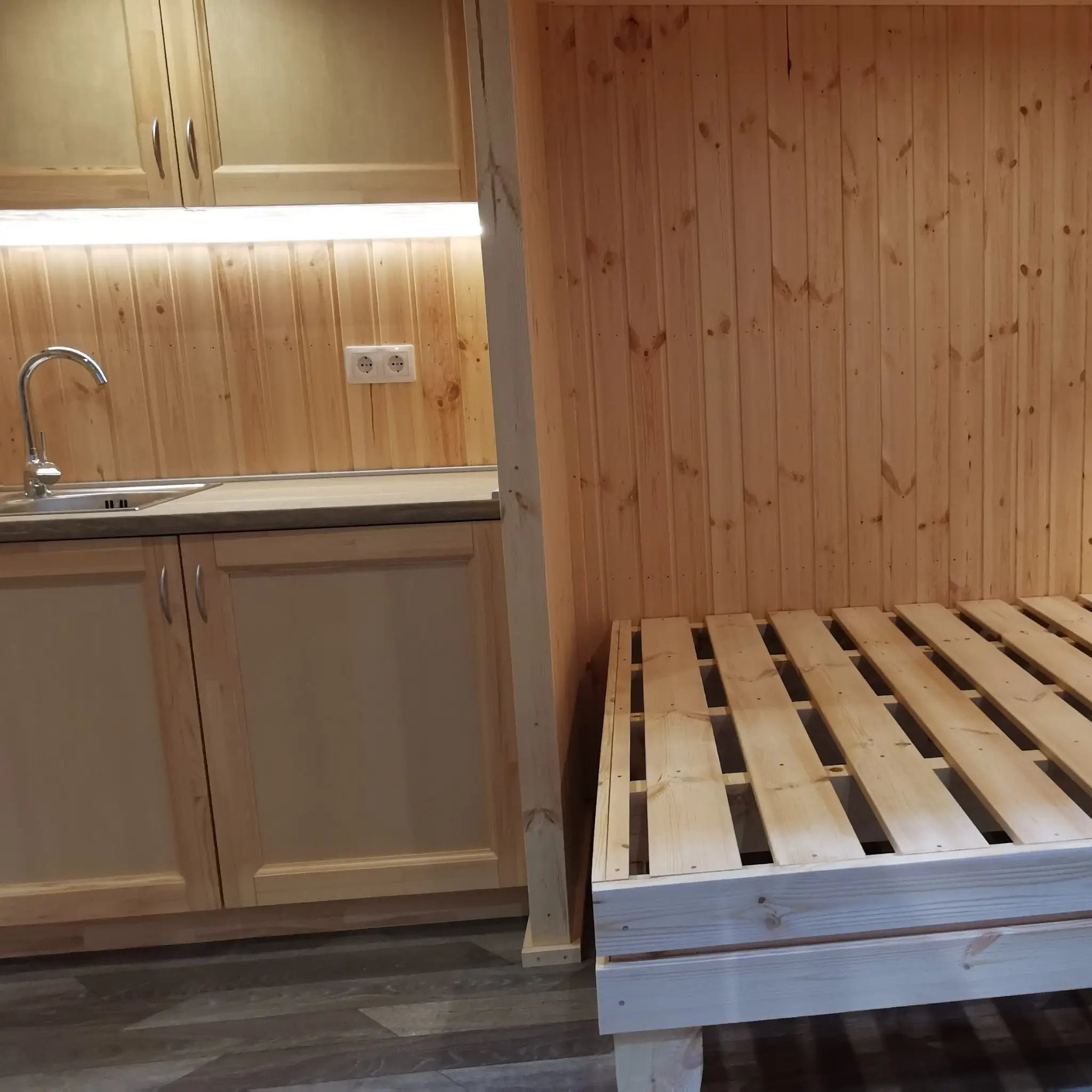 The Medium GlampTainer container-style glamping structure – space-saving layout with kitchenette beside built-in wooden bed frame
