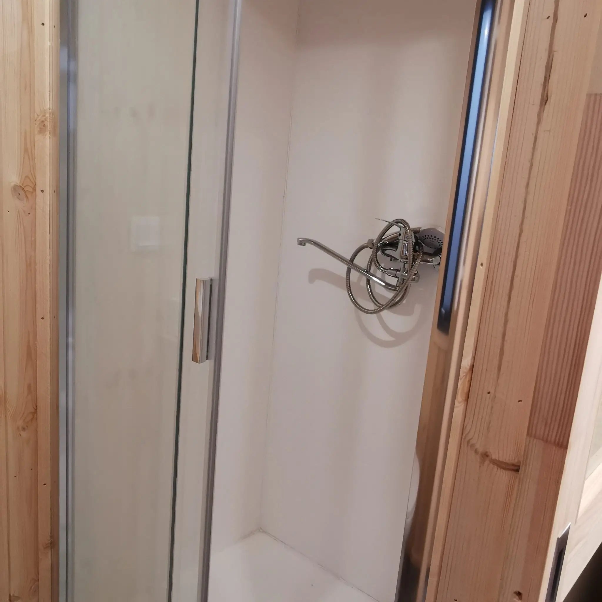 The Medium GlampTainer container-style glamping structure – minimalist standing shower unit with glass sliding doors and warm timber framing