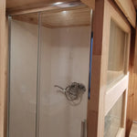 The Medium GlampTainer container-style glamping structure – close-up of modern standing shower with glass enclosure and chrome fixtures