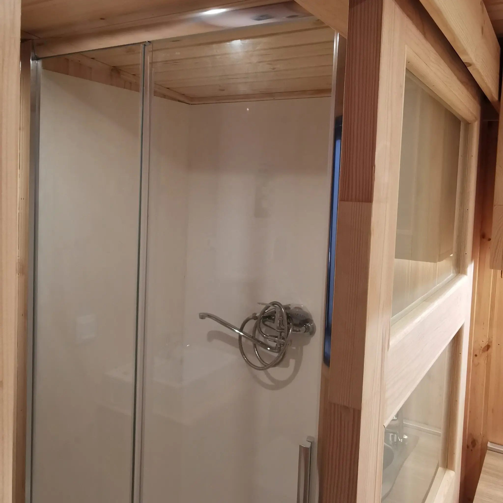 The Medium GlampTainer container-style glamping structure – close-up of modern standing shower with glass enclosure and chrome fixtures