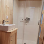 The Medium GlampTainer container-style glamping structure – bathroom with walk-in glass shower and square vanity sink on timber cabinet