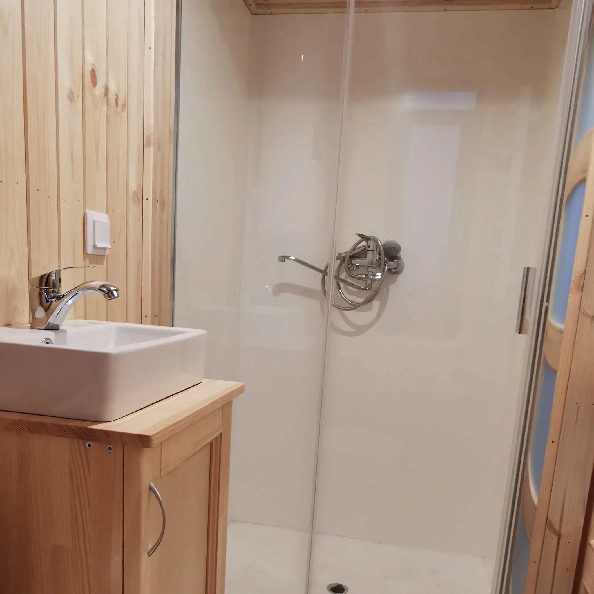 The Medium GlampTainer container-style glamping structure – bathroom with walk-in glass shower and square vanity sink on timber cabinet