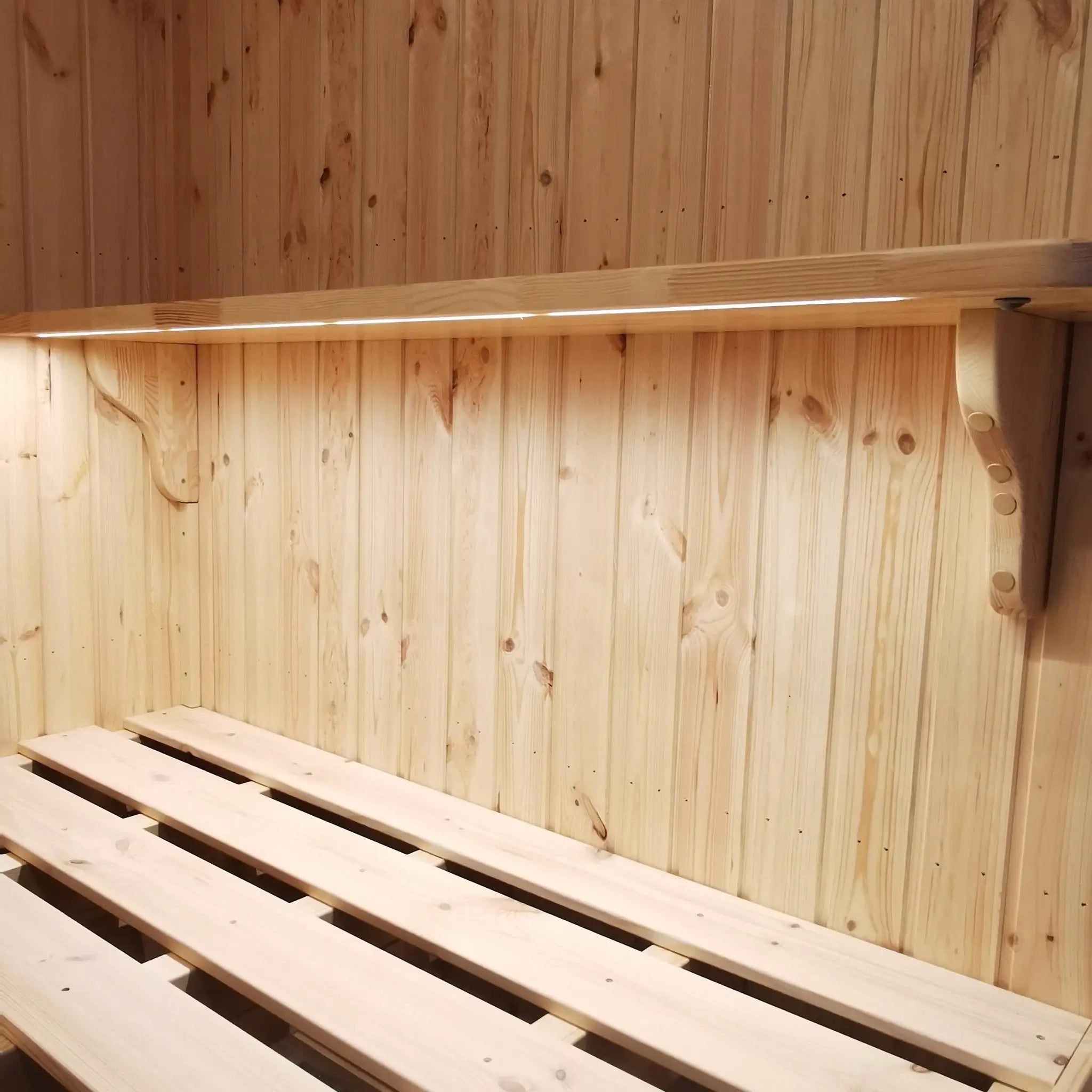 The Medium GlampTainer container-style glamping structure – minimalist wall-mounted shelf above solid wooden bed frame in cozy glamping pod