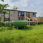 Luxury 2 person shepherd’s hut with private decking and outdoor bath overlooking countryside meadow