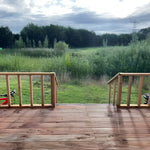 View from shepherd’s hut decking overlooking peaceful meadow and countryside landscape