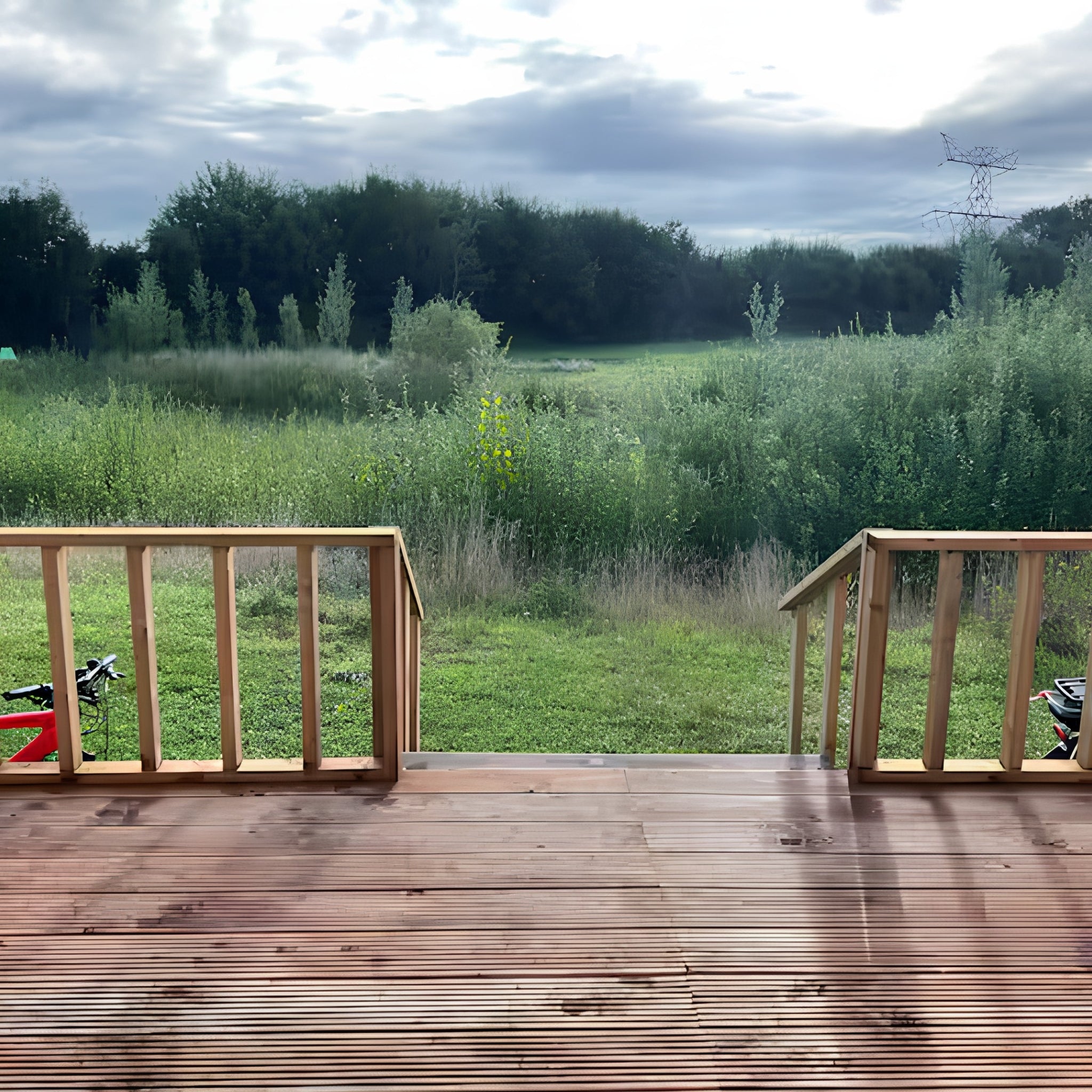 View from shepherd’s hut decking overlooking peaceful meadow and countryside landscape