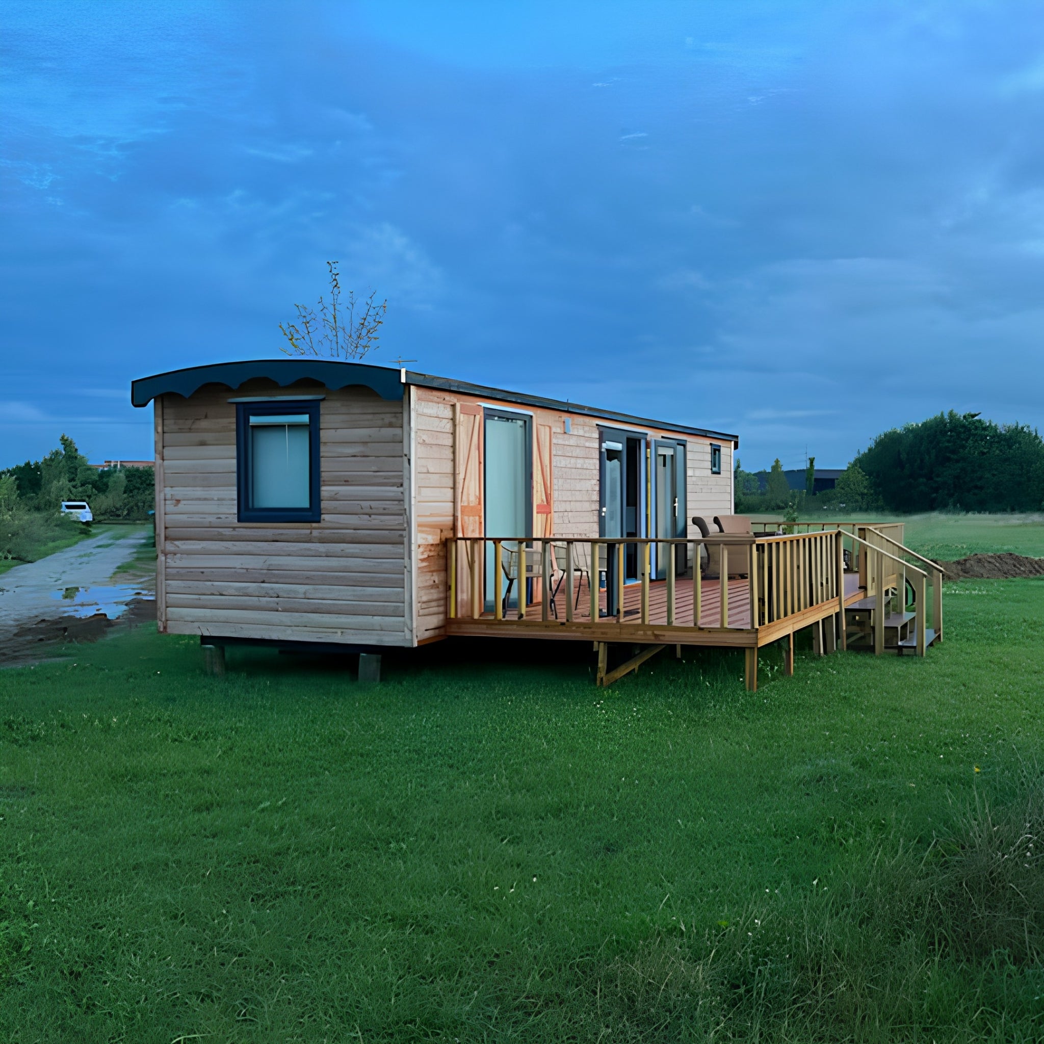 Luxury shepherd’s hut exterior at sunset with spacious deck and countryside views