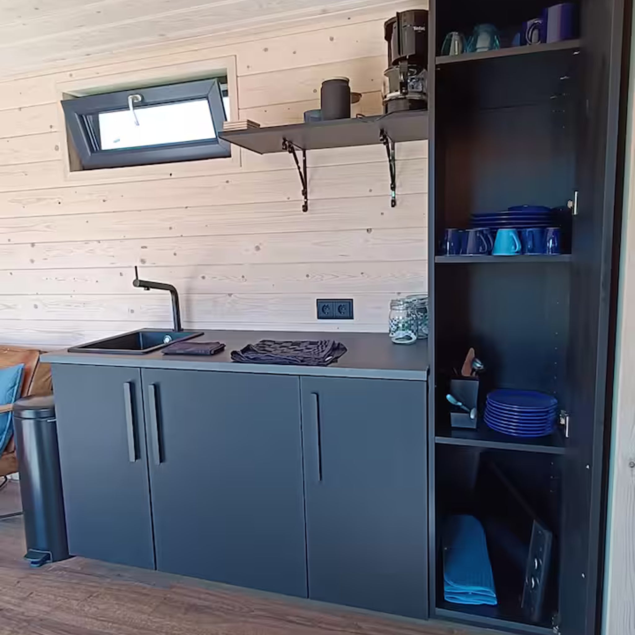 Modern kitchenette inside luxury shepherd’s hut with sink, storage and coffee station