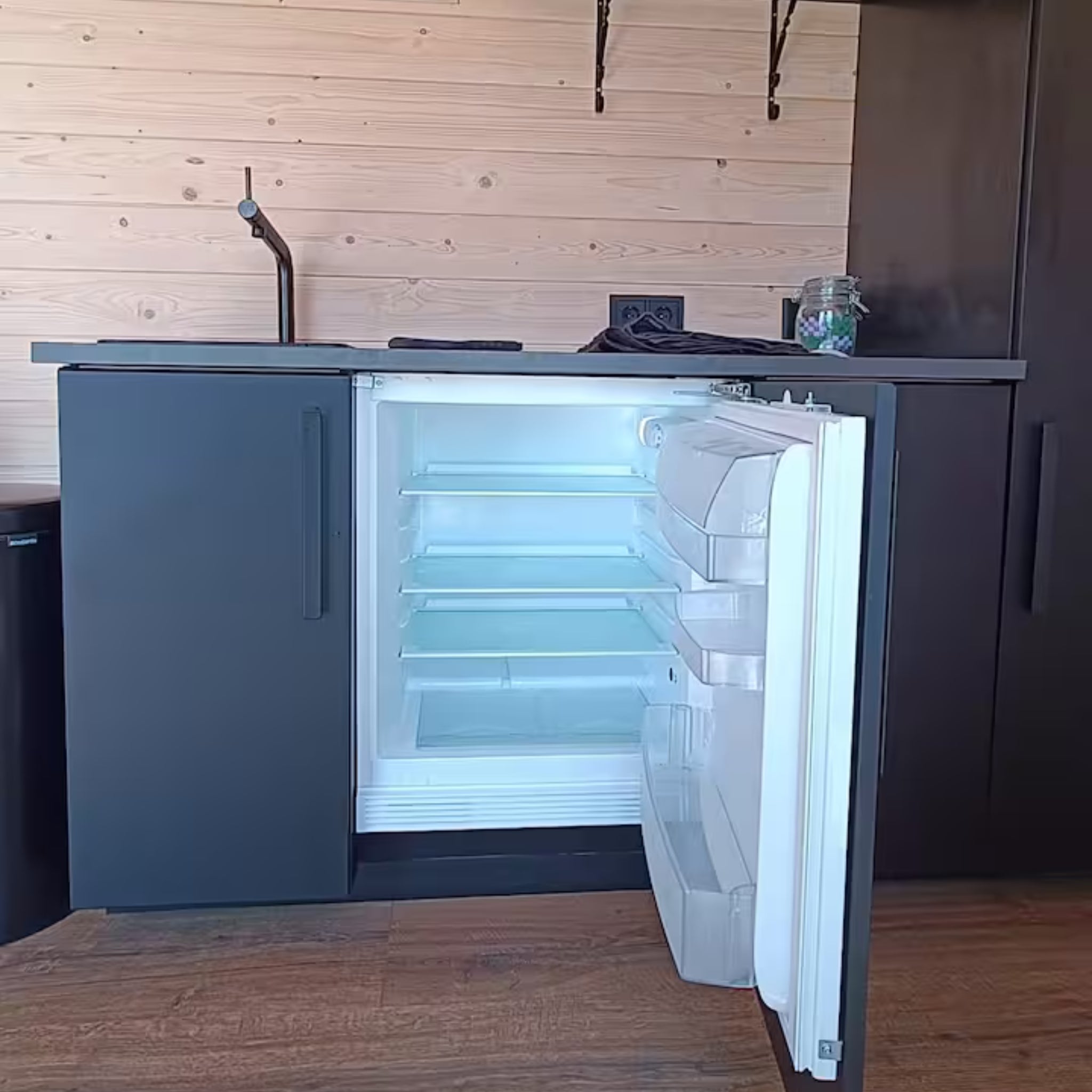 Compact mini fridge and modern kitchenette storage inside luxury shepherd’s hut